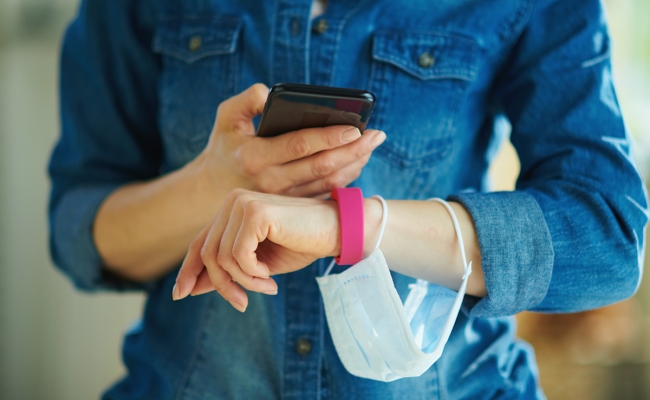 a smartphone and fitness tracker checking stats in the house