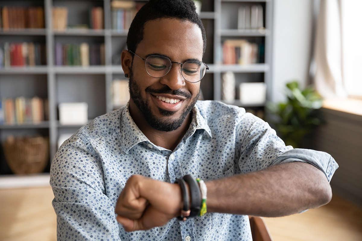 man looking at smartwatch while at home