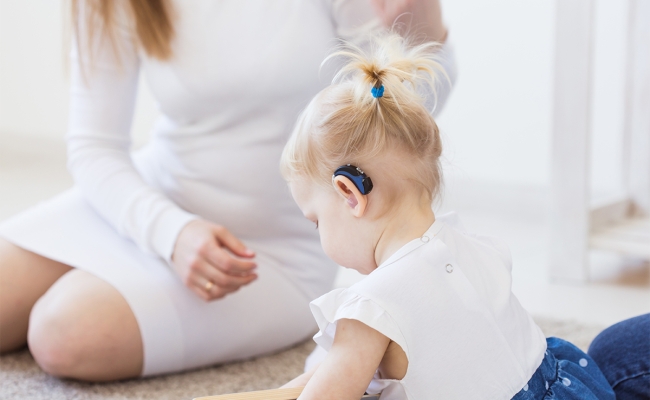 Toddler child wearing a hearing aid