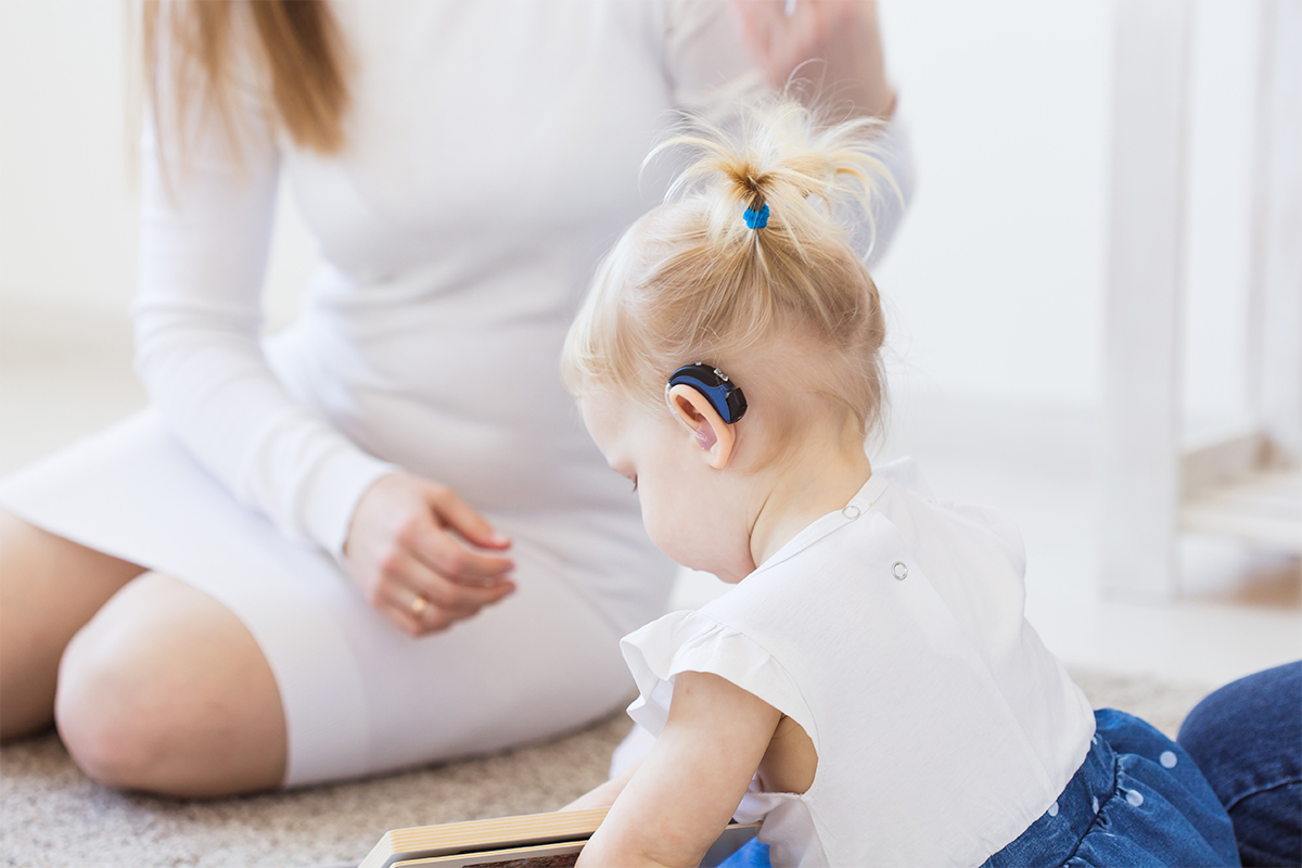 Toddler child wearing a hearing aid