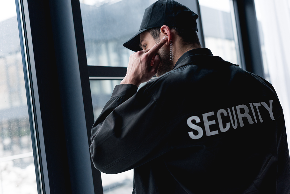 Security Guard wearing jacket and hat listening