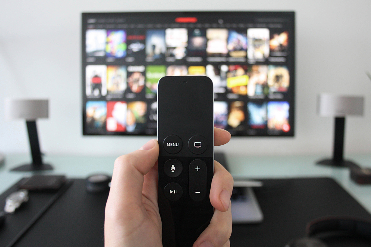 hand holding smart remote controller used to stream movies and shows