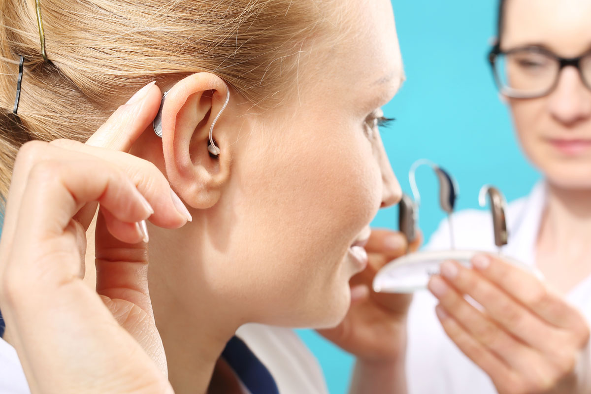 Doctor offering hearing aid to patient
