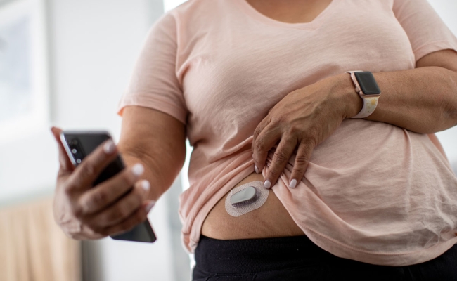 Woman using glucose monitoring system