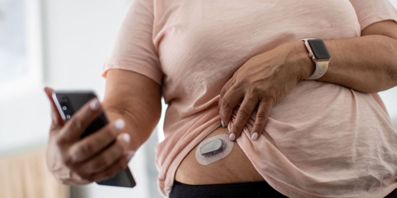 Woman using glucose monitoring system