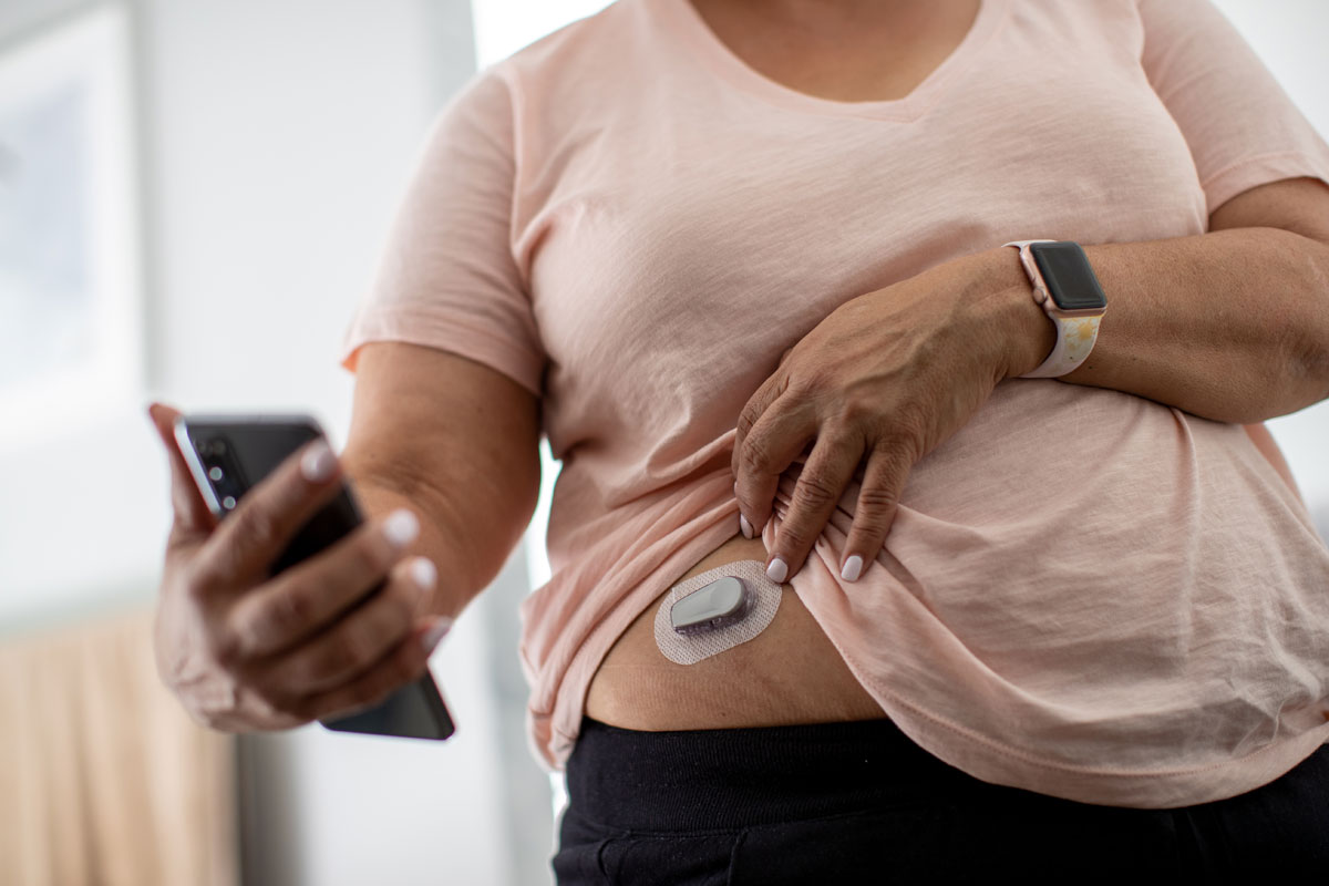 Woman using glucose monitoring system