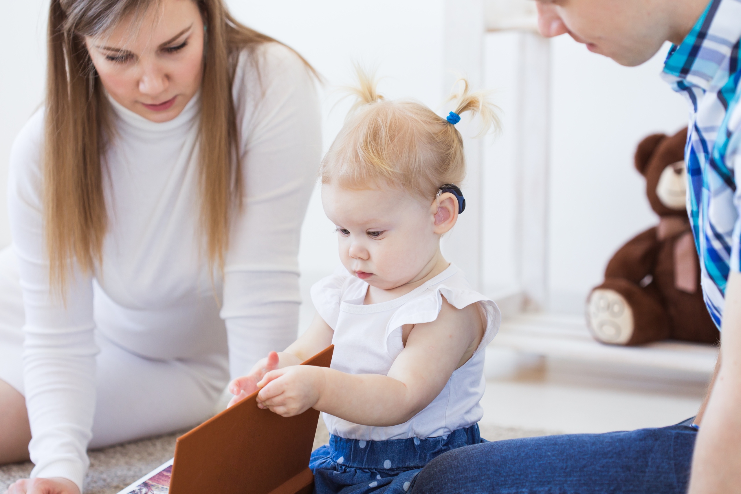 Baby girl wearing a hearing aid. Disabled child, disability and deafness concept.
